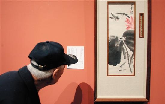 ��ʯ��ׯ���еġ��й����ִ��黭������Ʒչ���У�һλ�����ڹ������ʯ�Ļ滭��Ʒ��������ͼƬ��