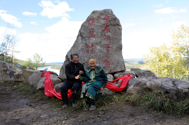于志学与鄂温克老猎人拉吉米老伴玛利亚索在中国冰雪画摇篮石碑前 张军摄